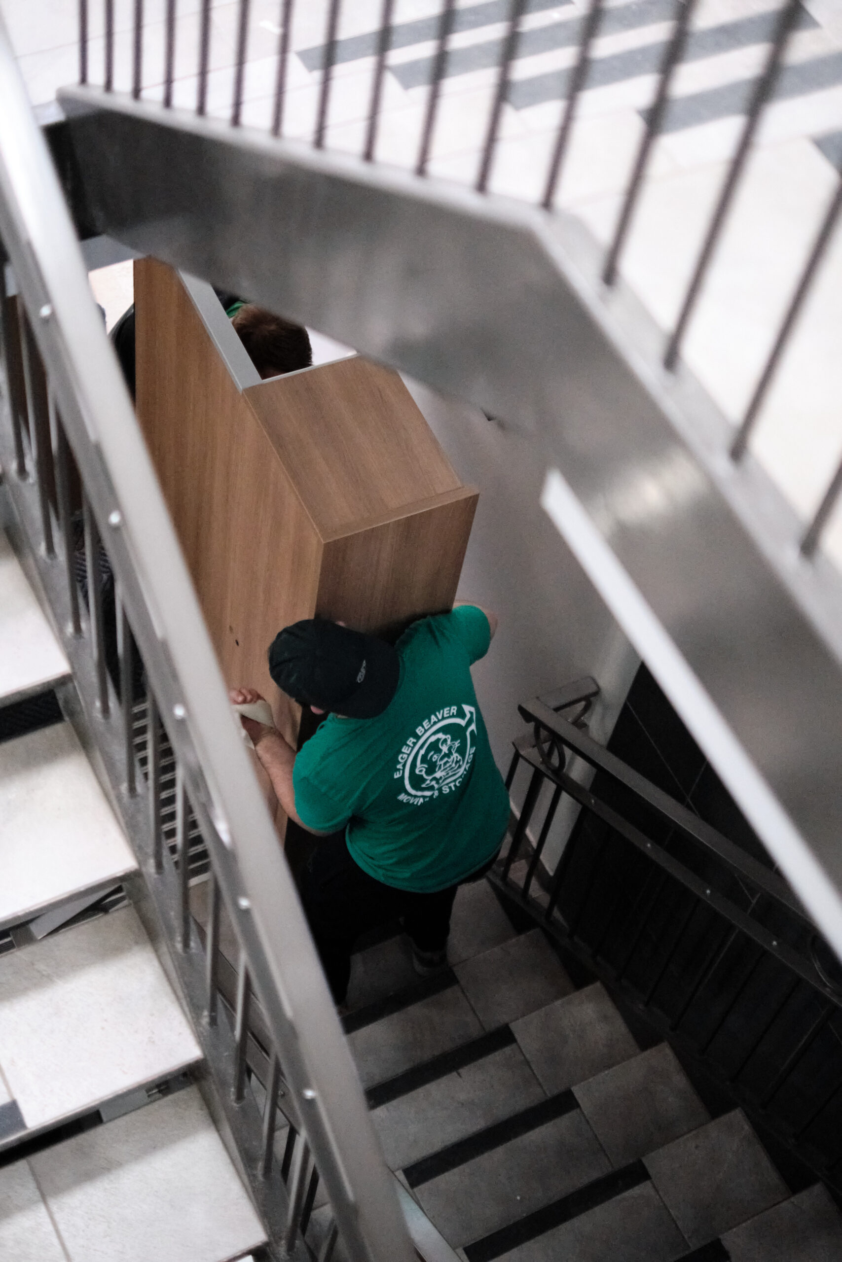 Movers relocating an office up a flight of stairs